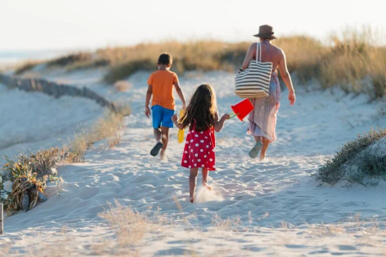 woman with 2 kids walking on the beach