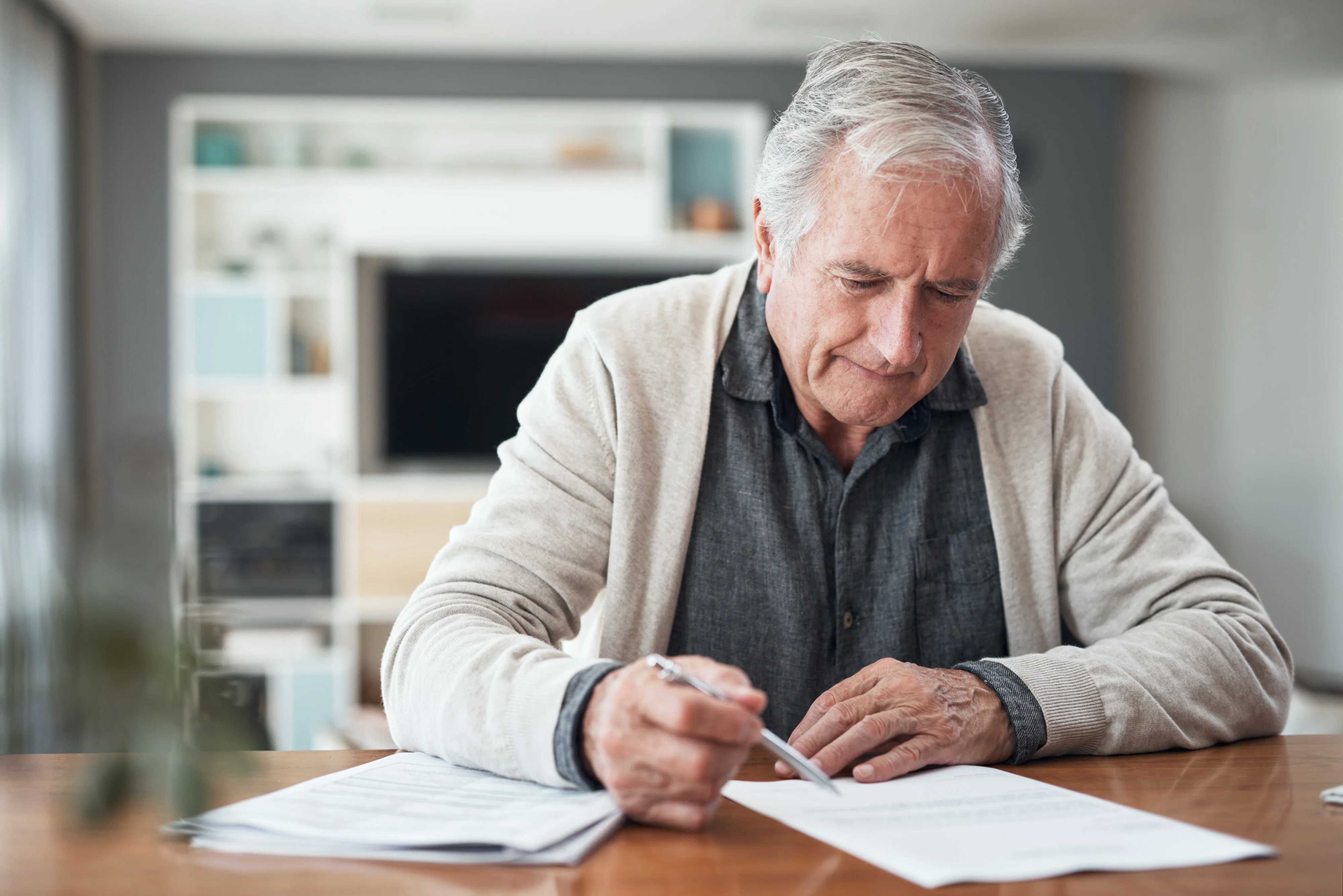 senior man sitting alone at home and going through his finances